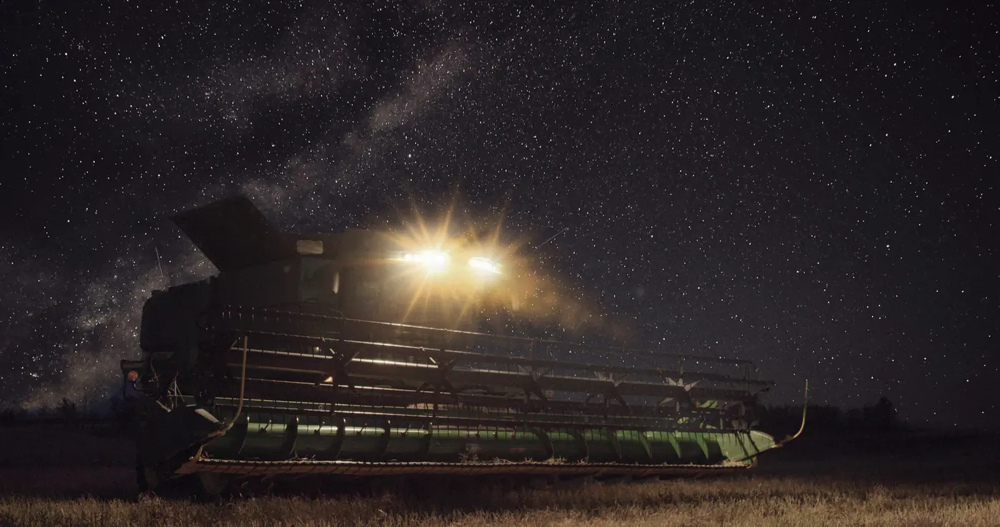 A combine harvesting under the Milky Way